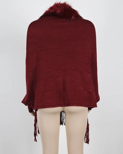 Rear view detail of wine red knit poncho featuring thick faux fur collar and fringe hem