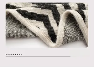 Detail shot of black and white striped knit texture and finished hemline on the poncho