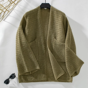 Détail du cardigan en maille vert olive avec grandes poches et texture côtelée