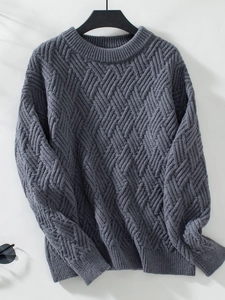 Close-up of grey cable knit sweater texture showing detailed diamond weave and stitching