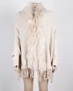 Detailed view of cream knit shawl with faux fur collar and long tassel hemline