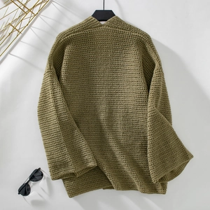 Texture macro du gilet en maille épaisse vert olive avec détail de poche surdimensionnée