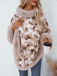 Close-up of leopard knit poncho with thick beige faux fur trim and soft winter texture