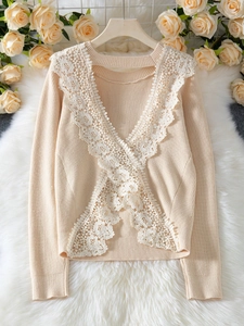 Detail of elegant knit sweater with deep V-neck lace trim and ribbed texture in beige