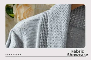 Macro shot of light gray knit cardigan fabric texture with delicate openwork stitch detail