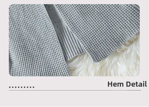 Detailed macro shot of grey waffle knit cardigan showing the ribbed hem and fabric texture