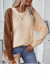Close-up of tricolor cable-knit sweater with ribbed cuffs and contrast stitch texture