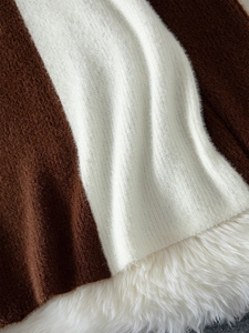 Close-up of two-tone brown and white knit fabric showing soft texture and button detail