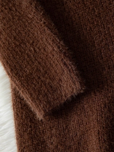 Macro detail of dark brown fuzzy knit sweater cuff showing soft mohair texture