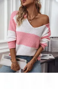 Dettaglio macro del maglione in maglia a righe rosa e bianche con scollo a V e polsini