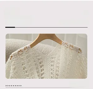 Close-up of V-neckline and intricate lace crochet texture on a cream knit shawl