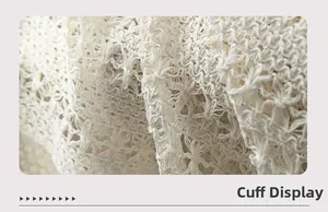 Detail shot of hollowed-out crochet lace cuffs on off-white knitted beach shawl