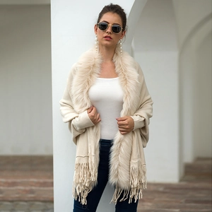 Beige knit poncho cape with faux fur collar and tassel trim for autumn and winter outfits