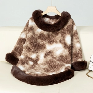 Detail of luxurious faux fur trim on a brown marble pattern knit poncho for winter