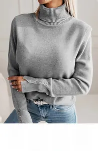 Detail view of the grey turtleneck sweater featuring four small buttons on the cuffs