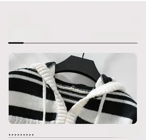 Detail of the hooded neckline with white drawstrings on a black and white striped sweater