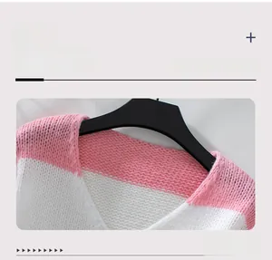 Dettaglio dello scollo a V e della trama in maglia a righe rosa del morbido maglione