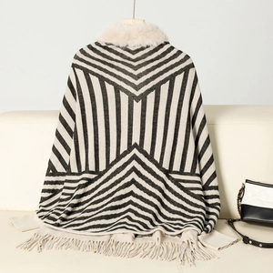 Detail of striped knit poncho featuring a plush beige faux fur collar and fringe hem