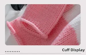 Dettaglio del polsino del maglione a maglia a righe rosa e bianche in trama grossa