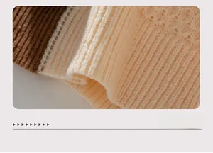 Detail of color-block sweater hem showing ribbed knit texture and cable stitching