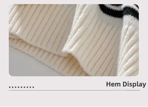 Close-up of off-white ribbed hem with black stripes on a knitted hooded sweater