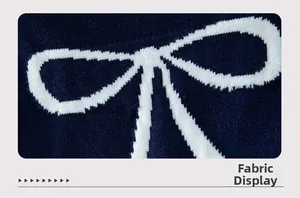 Macro view of navy knit fabric with white bow patterns showing soft material texture