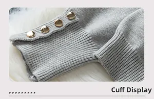 Close-up of grey ribbed cuffs featuring elegant gold button accents on a knit sweater