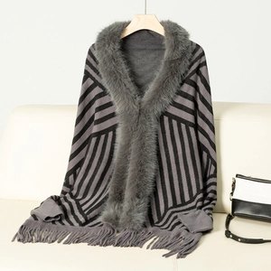 Detail of grey knitted shawl with faux fur collar, striped patterns, and tassel fringe