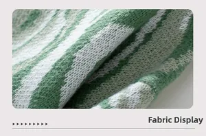 Close-up of fuzzy knit fabric featuring green and white abstract tiger stripe patterns