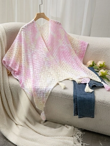 Close-up of pink and beige lace knit shawl featuring delicate floral texture and fringe