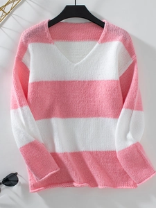 Dettaglio della trama in maglia a righe rosa e bianco e scollo a V del caldo maglione