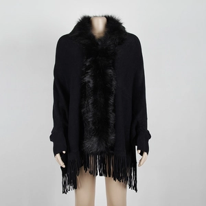 Elegant black knit poncho with luxury faux fur collar and fringe hem on mannequin