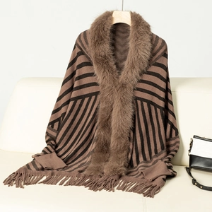 Detail of striped knit poncho with fringe hem and plush faux fur collar in brown and black