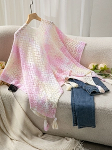 Detail of bohemian hollow-out crochet poncho with gradient pink tassels and lace texture