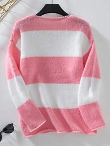 Dettaglio della morbida trama a maglia a righe rosa e bianche su un maglione a V