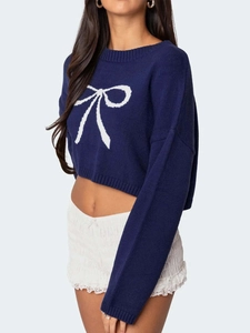 Navy blue cropped knit sweater with large white bow pattern and crew neck style