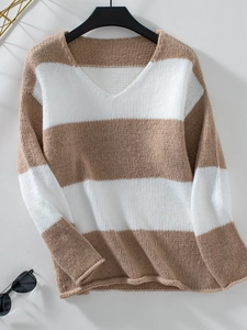 Dettaglio dello scollo a V e della trama in maglia sul maglione a righe bicolore