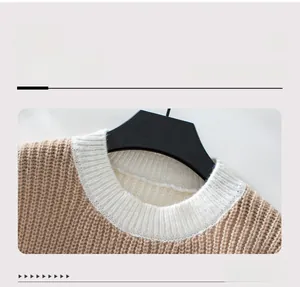 Detail eines farblich abgesetzten Rundhals-Pullovers mit beigem Zopfstrickmuster