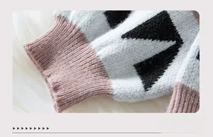 Detail of pink ribbed cuffs and black and white star jacquard knit sweater texture