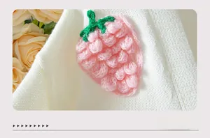 Détail en gros plan d'une fraise en crochet 3D sur un gilet en maille blanc