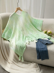 Close-up of bohemian knit poncho showing gradient lace texture and white fringe tassels