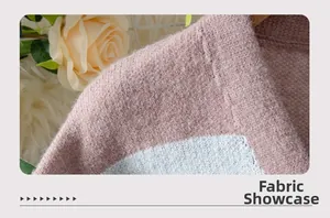 Close-up of soft pink and white knitted fabric texture and fine stitching on a cardigan