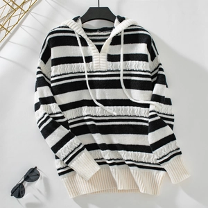 Detail of hooded striped knit sweater featuring cable knit texture and drawstring hood