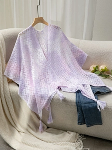 Close-up of lavender crochet shawl featuring delicate floral lace and fringe details