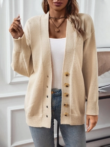 Cardigan beige en maille élégant avec boutons en écaille sur haut blanc et jean