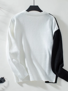 Detailed texture of round neck knit sweater with color-blocking and cable knit pattern