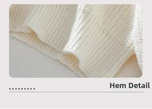 Detailansicht des gerippten Saums eines weißen Grobstrickpullovers mit Texturmustern