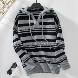 Close-up of striped knit hoodie featuring texture cable patterns and drawstring detail