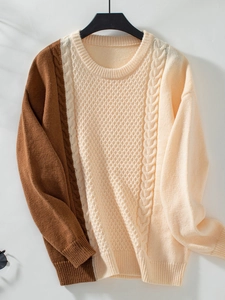 Detailed view of color-block knit sweater featuring cable knit patterns and ribbed cuffs