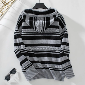 Detail of black and gray striped knit hoodie showing textured cable knit and ribbed cuffs